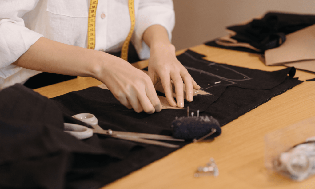 Woman skillfully repairing or mending clothes, ensuring their longevity and continued wearability.