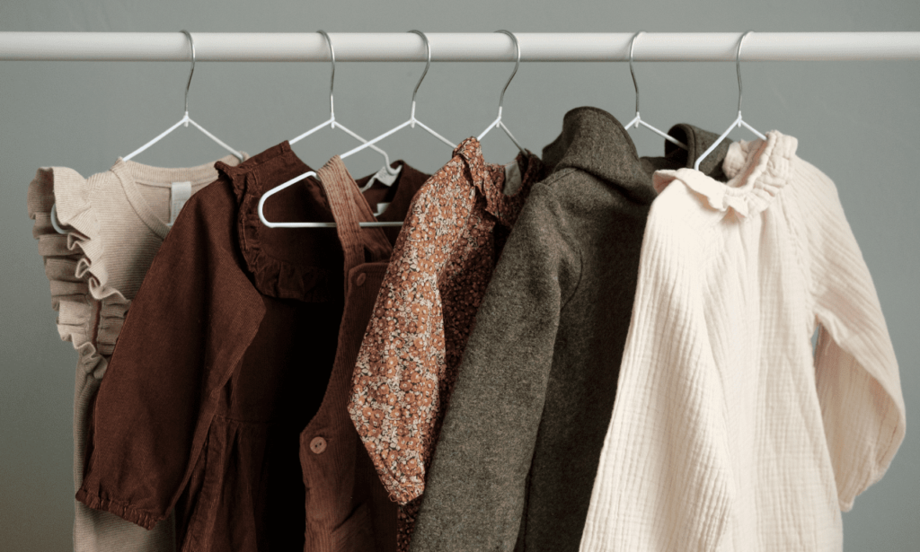 A closet filled with clothes in various shades of brown, neatly arranged on hangers