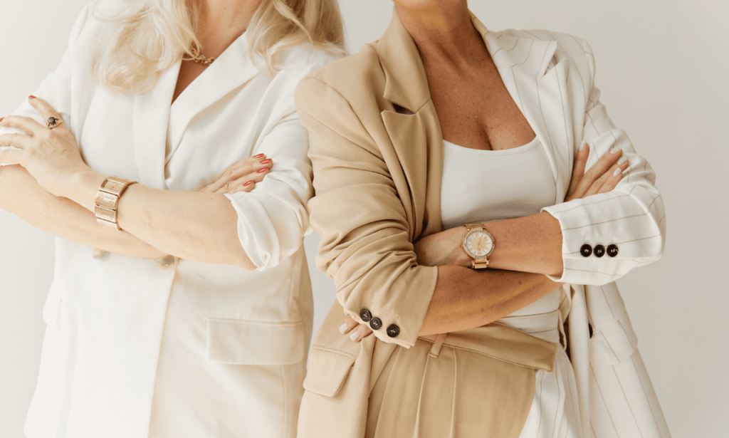 An image of two women dressed in neutral-toned business attire.