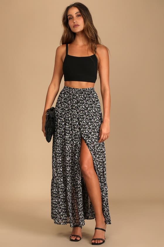 Woman dressed in a black floral print tiered maxi skirt with subtle sweetness