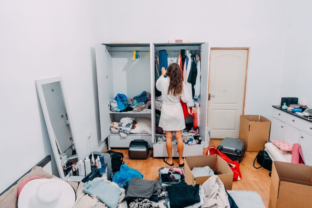Stylish woman in a modern apartment room preparing for a trip, following how to organize your closet tips