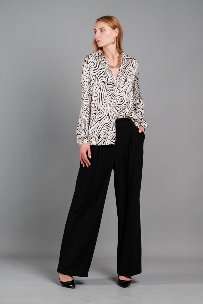 Fashionable woman wearing a blouse and pants in a studio setting for a portrait