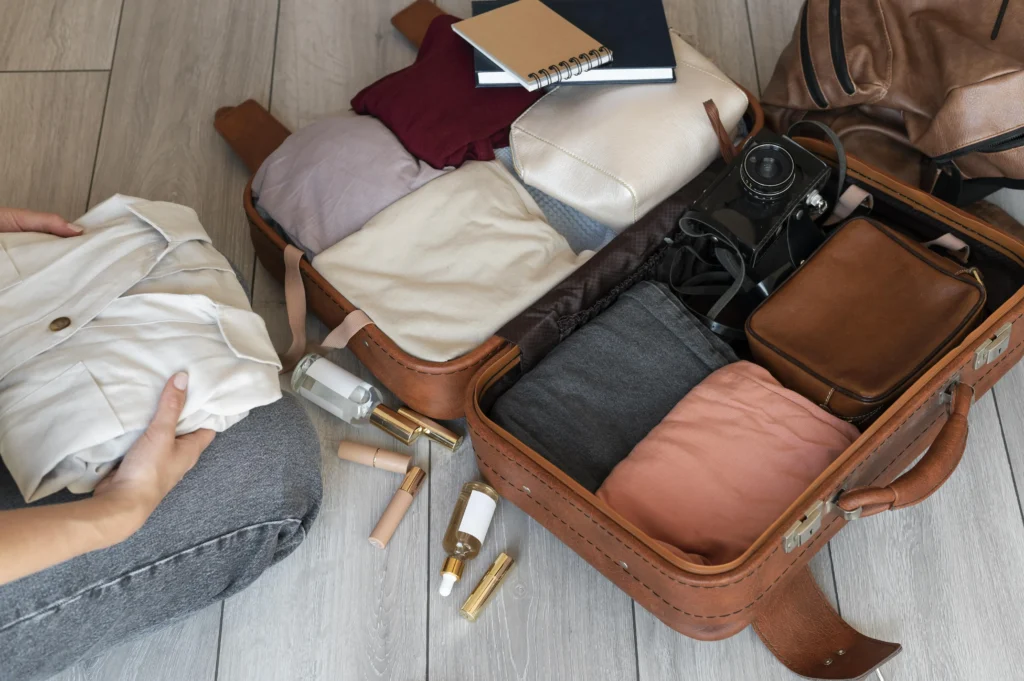 Photo of clothes and accessories neatly arranged in a suitcase.