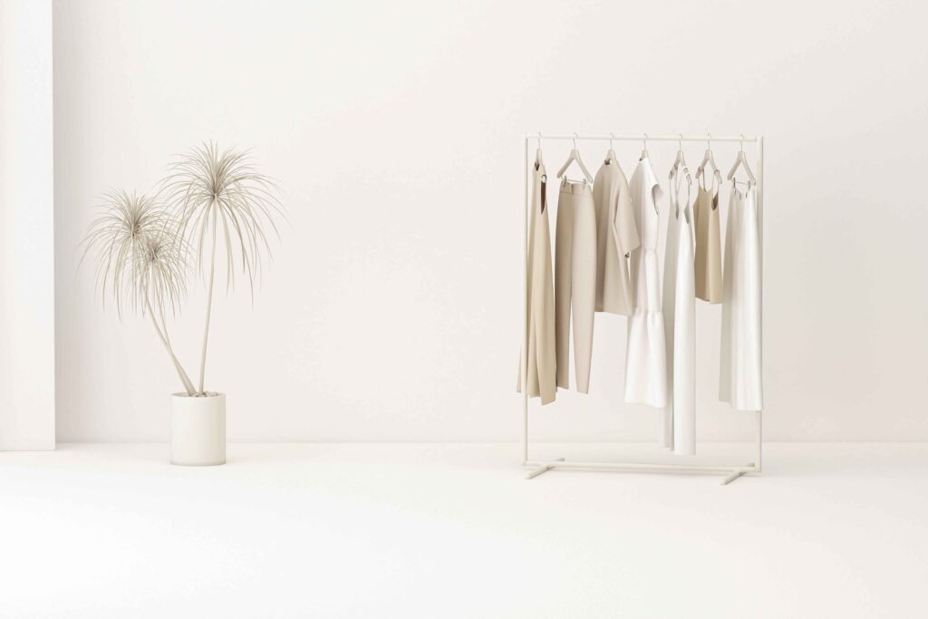 Image of a curated collection of clothes hanging on a rack against a grunge background, depicting the concept of a minimalist wardrobe.
