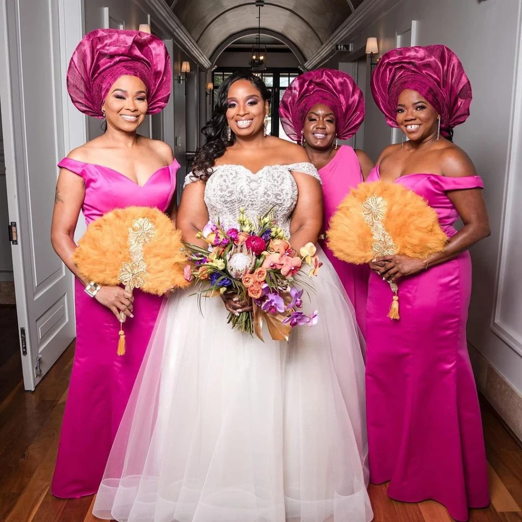 Cultural-themed wedding photo featuring African women in traditional attire posing with the bride.