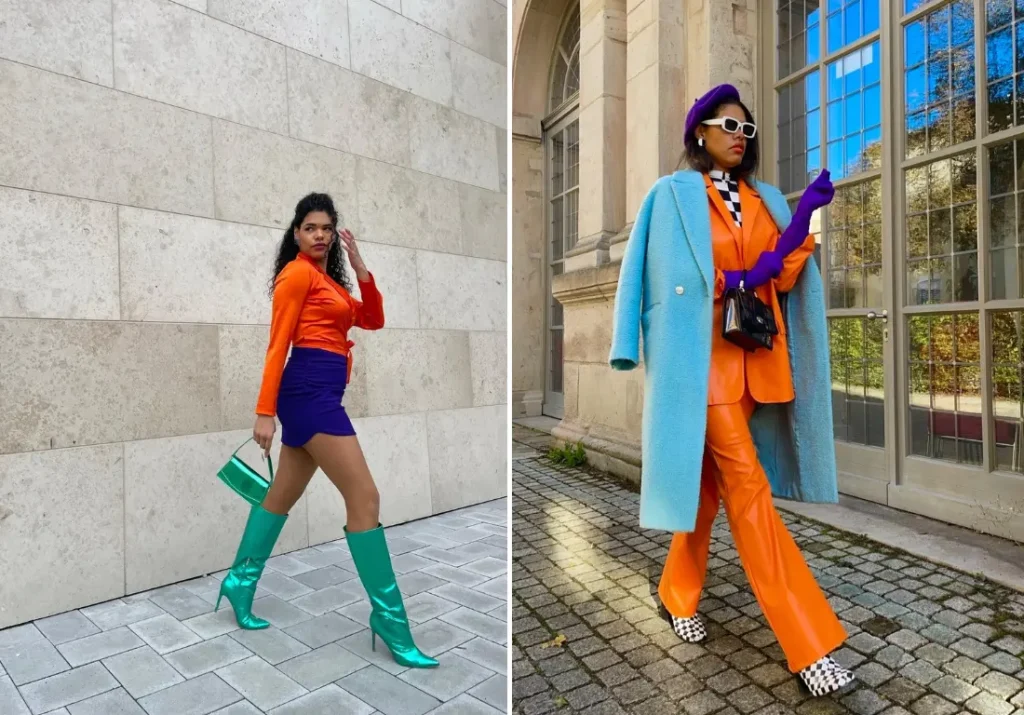 Two stylish women showcasing vibrant blue and orange outfits. The first woman wears a bold orange top with a purple skirt and teal boots, accessorized with a green handbag. The second woman pairs an orange suit with a light blue coat, purple gloves, and a beret, creating a striking and lively color combination perfect for those who love to stand out.