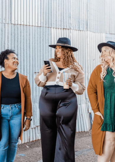 Group of women of different sizes, showcasing how to dress for your body type, wearing stylish bikinis and standing together against a brown background. Diverse women in swimwear looking at camera and smiling.