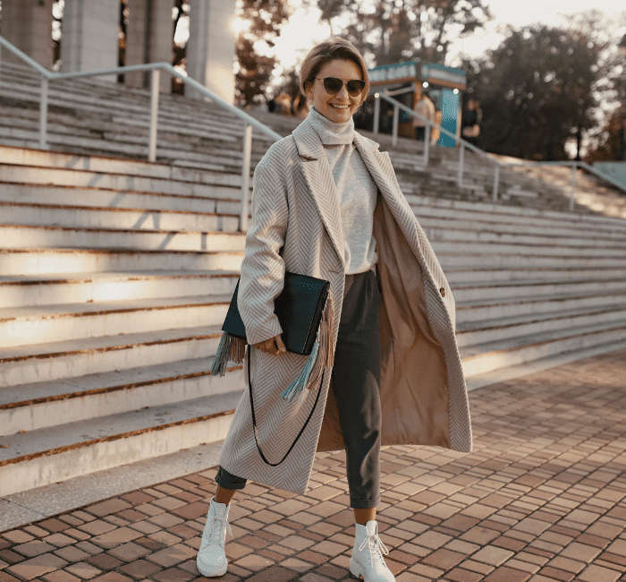Stylish confident fashionable woman walking in street in elegant style coat, building a stylish wardrobe.