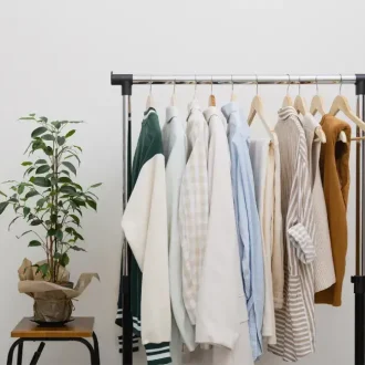 A minimalist wardrobe with neatly hung neutral-toned clothing on a rack, demonstrating how to upgrade your wardrobe with timeless pieces and sustainable fashion choices.