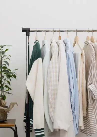 A minimalist wardrobe with neatly hung neutral-toned clothing on a rack, demonstrating how to upgrade your wardrobe with timeless pieces and sustainable fashion choices.