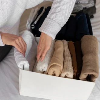 Free photo close up of hands holding clothes showcasing benefits of a capsule wardrobe.