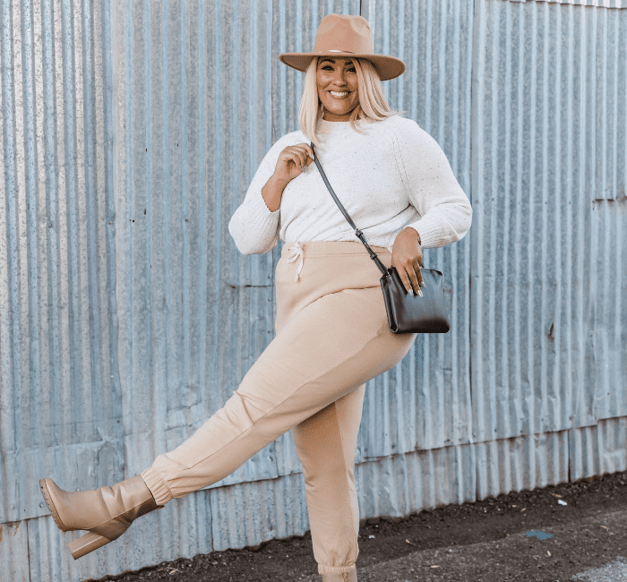 Stylish Plus Size Woman Posing Near Corrugated Metal Wall with Her Plus Size Capsule Wardrobe