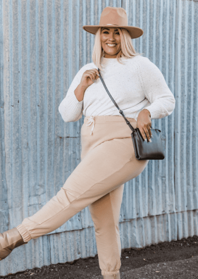 Stylish Plus Size Woman Posing Near Corrugated Metal Wall with Her Plus Size Capsule Wardrobe