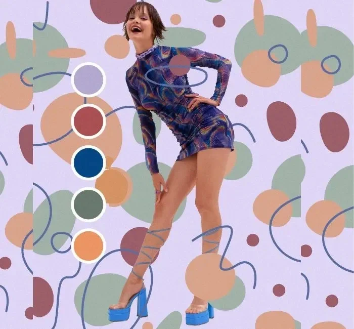 A woman dressed in a vibrant, multicolored outfit stands against a background of abstract patterns. The image showcases the practical application of color theory in fashion. The woman’s outfit features shades of blue, green, and orange, demonstrating how different colors can be harmonized to create a stylish look.