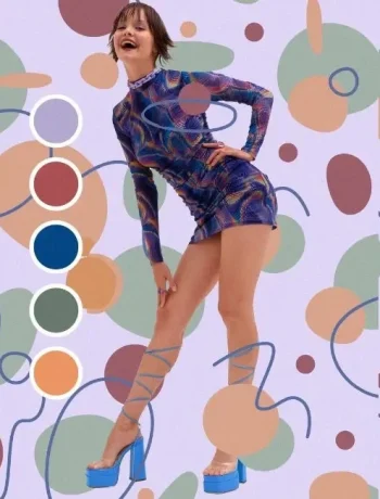 A woman dressed in a vibrant, multicolored outfit stands against a background of abstract patterns. The image showcases the practical application of color theory in fashion. The woman’s outfit features shades of blue, green, and orange, demonstrating how different colors can be harmonized to create a stylish look.