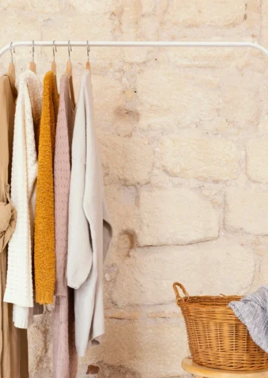 Neutral-toned women's apparel arranged on a clothing rack, demonstrating a minimalist capsule wardrobe concept.