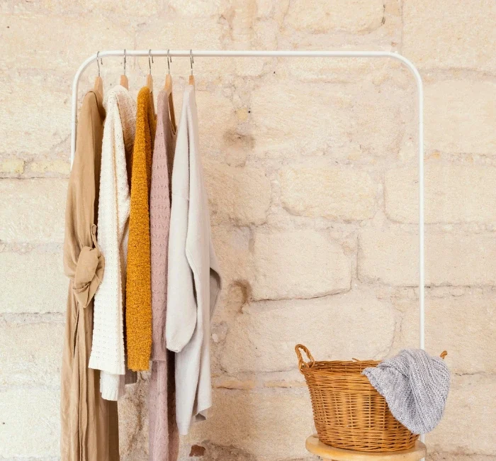 Neutral-toned women's apparel arranged on a clothing rack, demonstrating a minimalist capsule wardrobe concept.