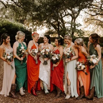 Cohort of ladies donned in varied wedding guest attire, captured in a photograph while holding bouquets.