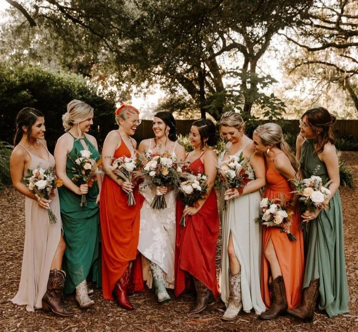 Cohort of ladies donned in varied wedding guest attire, captured in a photograph while holding bouquets.