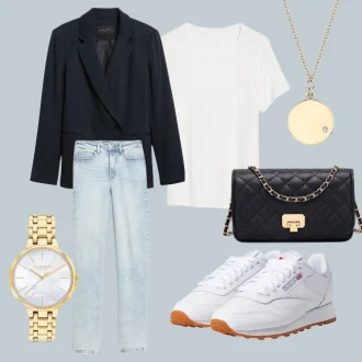 Fall capsule wardrobe 2023: An ensemble from the autumn capsule collection featuring a white shoe, a navy blue blazer, light wash denim jeans, a golden necklace and watch, completed with a black cross-body bag and crisp white shirt.
