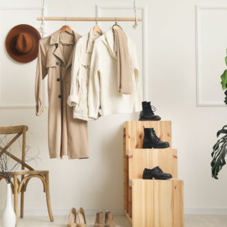 A wardrobe showcase featuring a trench coat, black boots, and fedora hats.