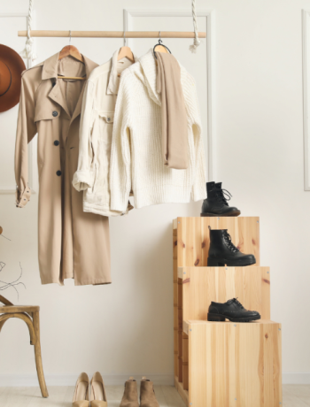 A wardrobe showcase featuring a trench coat, black boots, and fedora hats.