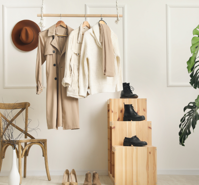 A wardrobe showcase featuring a trench coat, black boots, and fedora hats.