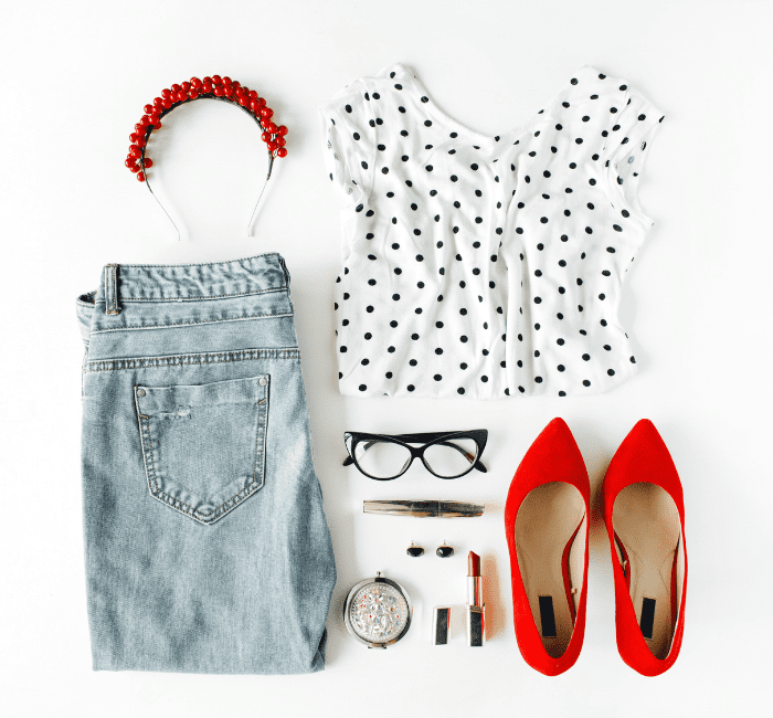 A captivating collage of chic feminine attire and accessories, artfully arranged in a flat lay composition on a pristine white backdrop. This stylish ensemble, featuring a blouse, jeans, sleek eyewear, lush mascara, bold lipstick, fiery red high heels, and dazzling earrings and hoops, creates a harmonious fusion of match outfits, perfect for any fashion-forward woman.