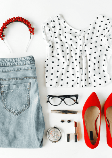 A captivating collage of chic feminine attire and accessories, artfully arranged in a flat lay composition on a pristine white backdrop. This stylish ensemble, featuring a blouse, jeans, sleek eyewear, lush mascara, bold lipstick, fiery red high heels, and dazzling earrings and hoops, creates a harmonious fusion of match outfits, perfect for any fashion-forward woman.